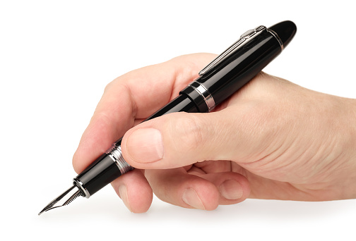 Hand holding classic black fountain pen, writing or drawing, close-up shot, isolated on white background