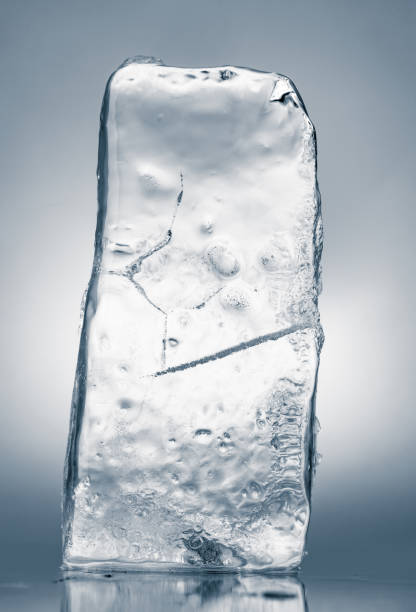 istock Crystal clear natural textured ice block on a reflective surface. 2032957098