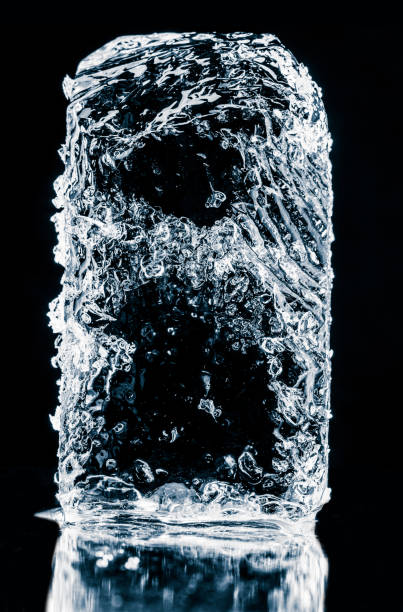 istock Crystal clear natural textured ice block on a black reflective surface. 2032957135