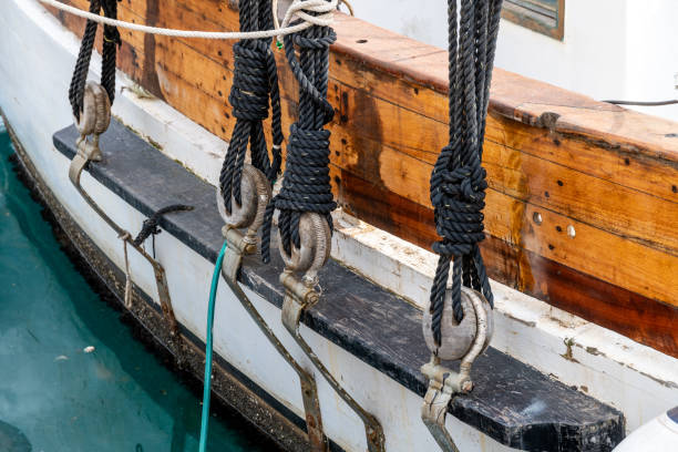Historic Sailing Ship Rigging and Knots Detail Cartagena, Murcia - Spain - 01-16-2024: Close-up of traditional sailing ship's rigging, featuring knotted ropes, wooden deadeyes, and taut steel cables against wooden hull gaff sails stock pictures, royalty-free photos & images