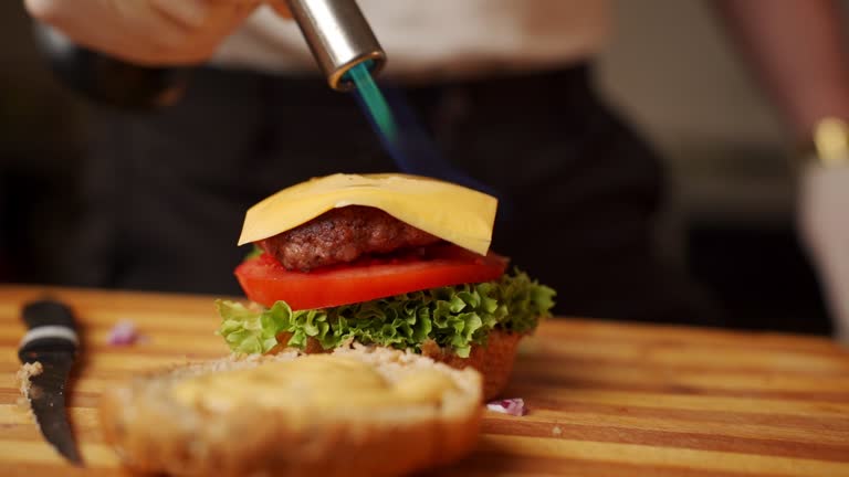 Adult man making a burger in kitchen