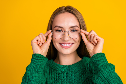 Closeup portrait of cheerful blonde hair business lady trying her new eyeglasses before working day isolated on yellow color background.