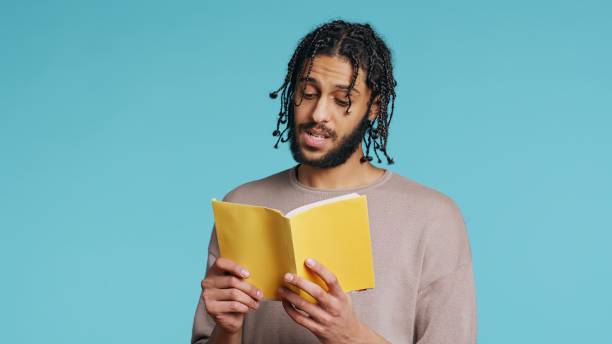 istock Man reading newly released hardcover book from publisher, studio background 2033089425