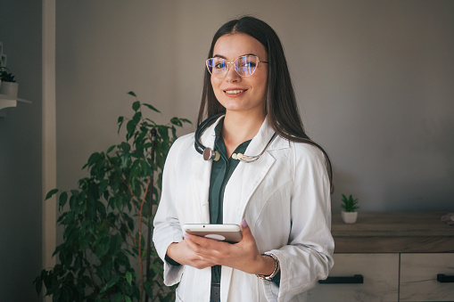 Image of a young female doctor using a digital tablet at home.