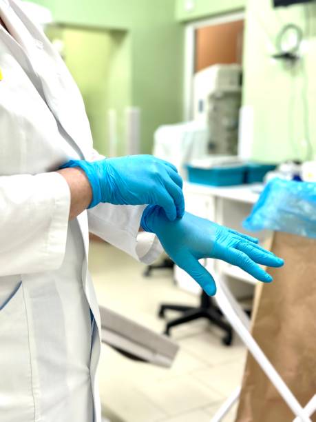 istock The medical worker puts on blue gloves. 2033134177