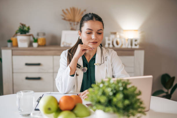 istock Young lady doctor in white medical uniform using computer laptop. 2033140582