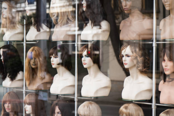 istock Rows of hair wigs on display, on dummies, in a store 2033144322