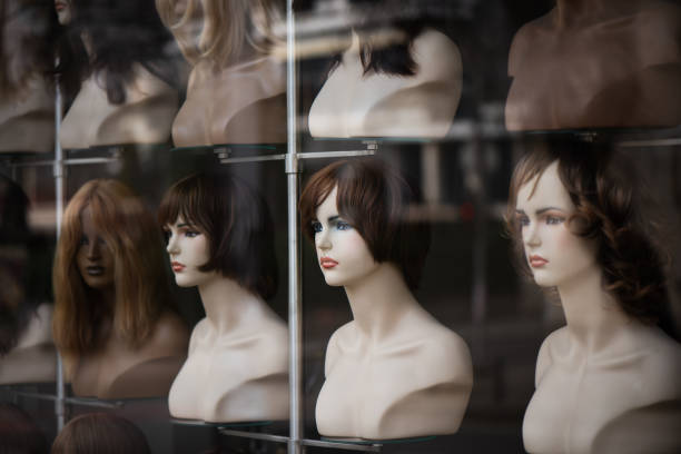 istock Rows of hair wigs on display, on dummies, in a store 2033144329