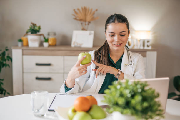 istock Young lady doctor in white medical uniform using computer laptop. 2033145993