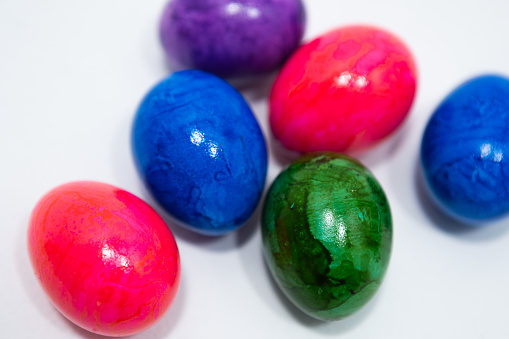 Basket full of colourful eggs coloured for Easter season. No people.