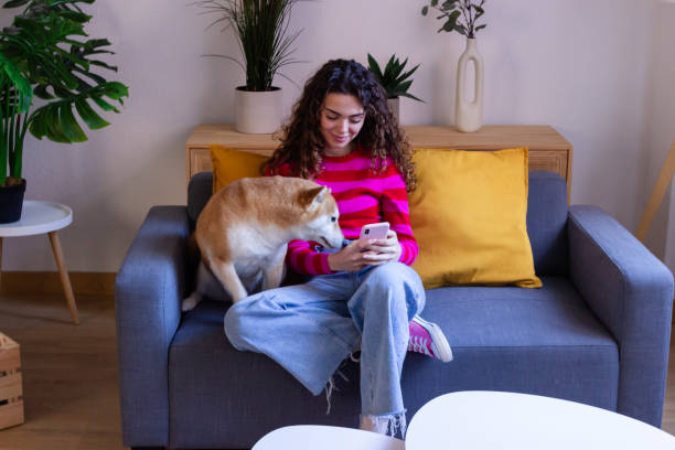 istock Young woman relaxing on couch with her dog 2033177325