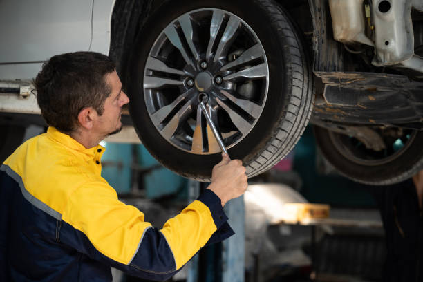 istock Hardworking mechanic changing car wheel in auto repair workshop. Oxus 2033184712