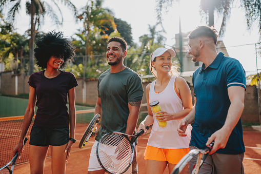 Group of friends playing tennis on the court