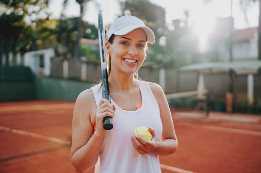 Portrait of a woman on the tennis court holding racket