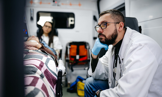 Doctors having a stressful day in an ambulance vehicle