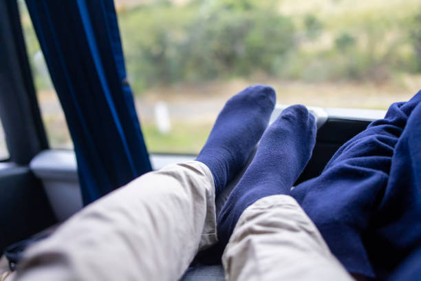 A pair of striped slippers are laying on the ground. The slippers are blue and white and have a striped pattern