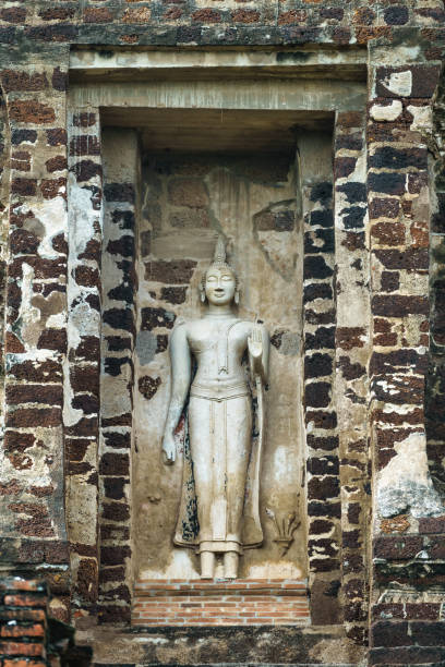Statue on the prang of Wat Ratchaburana in Ayutthaya Historical Park, Ayutthaya, Thailand on a cloudy day, UNESCO World Heritage Site.