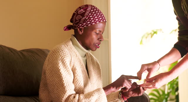 Medication Assistance: Nurse Administers Pills to Woman with Cancer