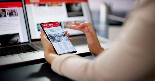 Watching Online News Article On Mobile Phone And Laptop