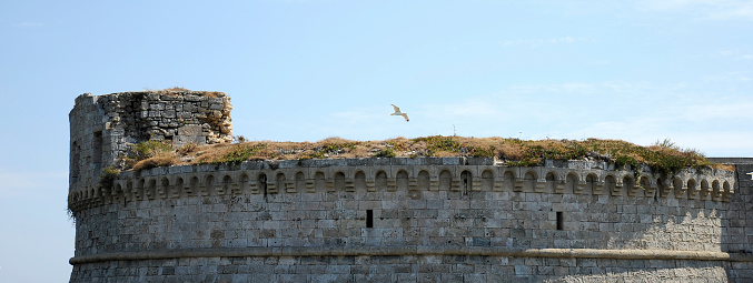 Horizontal banner or header with defensive medieval tower of Gallipoli Castle. Old fortress Angevine-Aragonese in Gallipoli, town in Southern Italy, Apulia, Italy - Concept of historical tourism