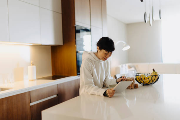 istock Woman eating her breakfast and using digital tablet 2033311852