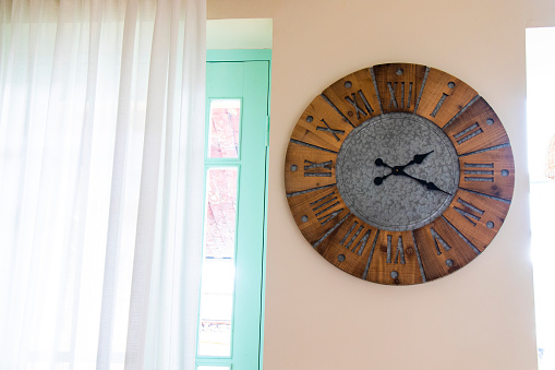 Large clock hanging on wall next to window