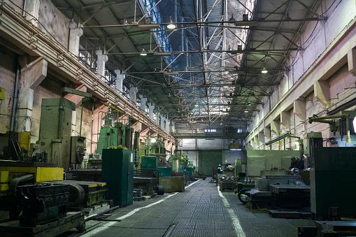 Industrial interior of heavy machinery workshop, large hall with machines, tools for metalwork, manufacturing production line, workspace for manual labor, metal industry background no people.
