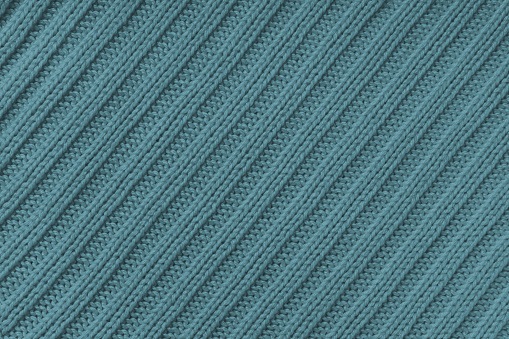 Jersey textile background , green-gray diagonal striped knitted fabric. Woolen knitwear, sweater, pullover surface texture, textile structure, cloth surface, weaving of knitwear material