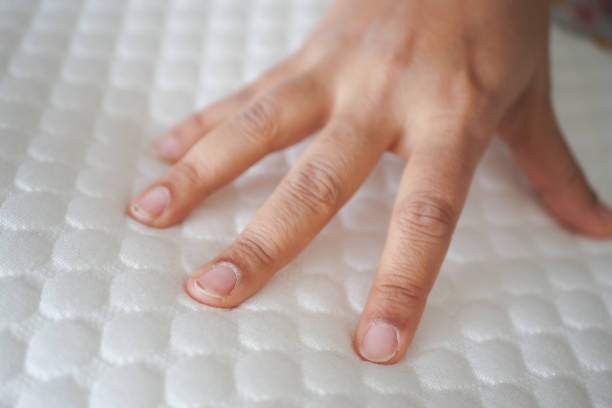 istock Hand touching and pressing orthopedic mattress on bed. 2033406111