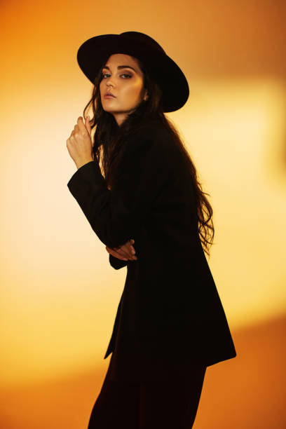 istock Brunette woman in black suit and hat in studio. Retro style 2033469501