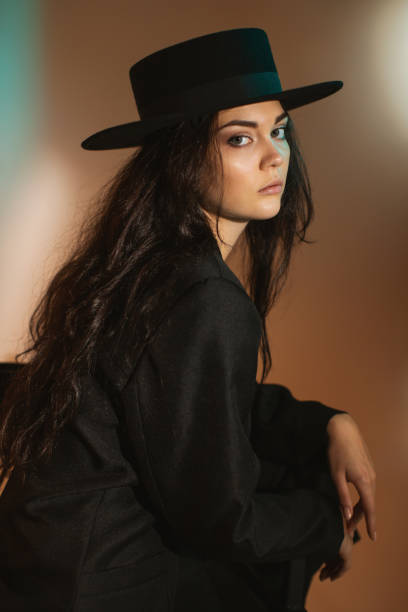 istock Brunette woman in black suit and hat in studio. Retro style 2033475816