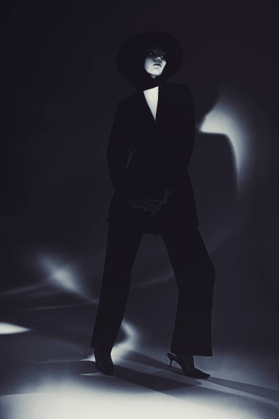 istock Brunette woman in black suit and hat in studio. Retro style 2033491478