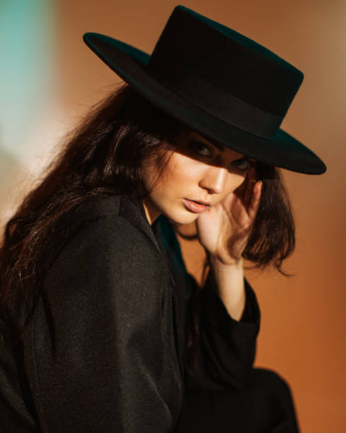 istock Brunette woman in black suit and hat in studio. Retro style 2033497785