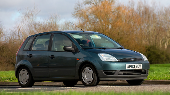 Milton Keynes,UK-Feb 23rd 2024: 2003 green Ford Fiesta car driving on an English road