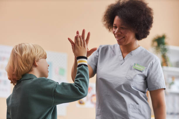 istock Black Nurse High Five with Little Boy in Clinic 2033567951