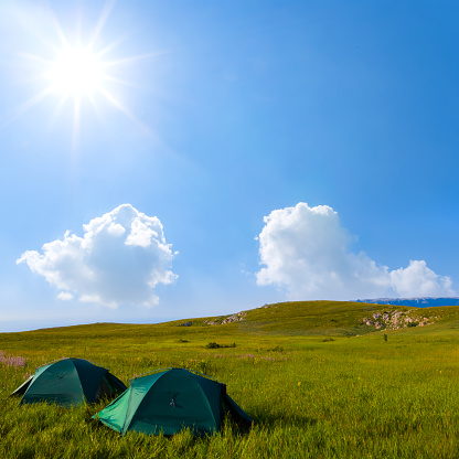 touristic camp among green hills at sunny day, summer travel scene