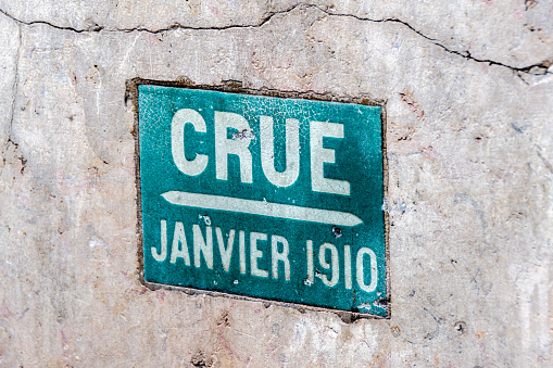 Paris, France - February 23, 2024: Plate on the wall of a Parisian building indicating the level reached by the water during the great historic flood of the Seine river in January 1910 in Paris