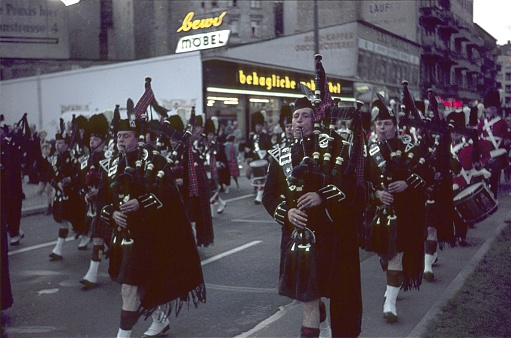 Berlin (West), Germany, 1965. British military marching band with Scottish bagpipers on Allied Forces Day in Berlin West. Also: spectators and buildings.