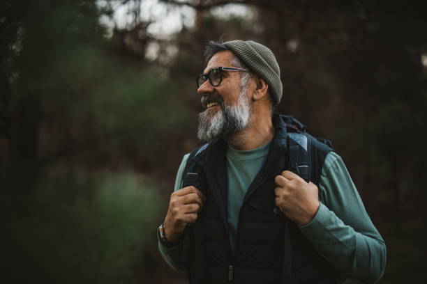 Active senior hiker Portrait of mature man with backpack and camera hiking and taking photos in nature. potential energy stock pictures, royalty-free photos & images