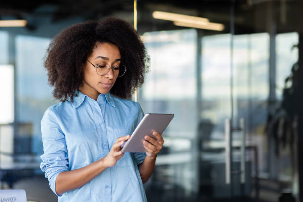 istock White-collar worker with electric blue eyewear using tablet in office building 2033756129