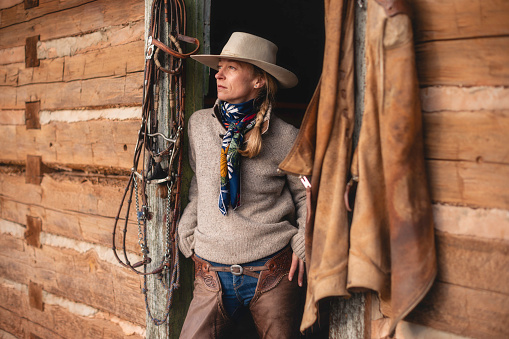 Female ranch worker portrait at a Wyoming horse ranch in the winter in a rural landscape.