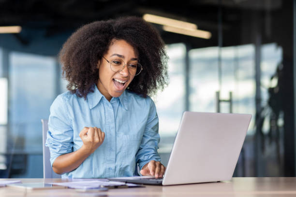istock Smiling woman at a creative office event, working on laptop at a table 2033780497