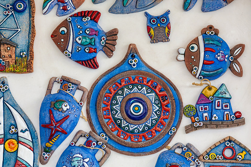 Handmade creative magnets: evil eye, fish, cats, owls, houses. Ceramic, blue, vibrant colors. Various colorful fridge magnets to remind travel. October 12, 2023. Bodrum, Turkey (Turkiye)