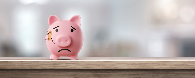 sad and broken pink piggy bank with a blessed one - concept of failure in saving and bad finances