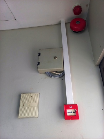 Fire alarm button on the wall, red emergency bell