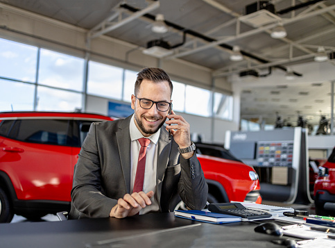 The diligent work of a man finalizing paperwork in the showroom highlights the behind-the-scenes effort that goes into delivering customer satisfaction and driving dreams off the lot