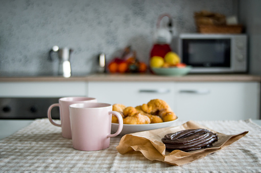 Indoor Home with two Coffee Cups of Liquid Hot Chocolate, Buñuelos and a Chocolate Churro. Las Fallas Party Sugar Food