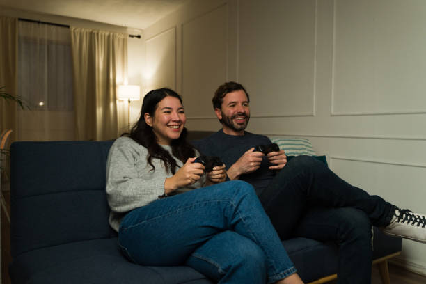 istock Happy couple having fun playing video games on the couch 2033918652