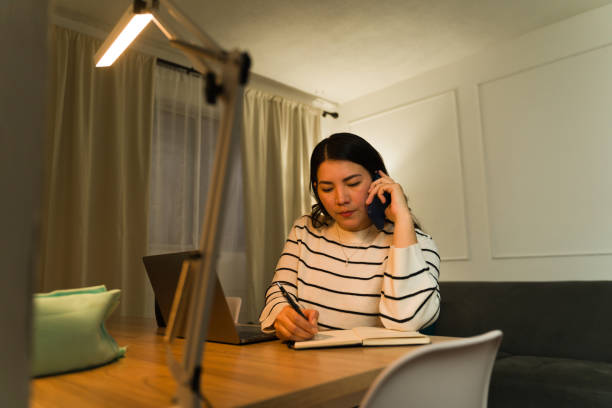 istock Attractive woman working from home talking on the phone 2033927554