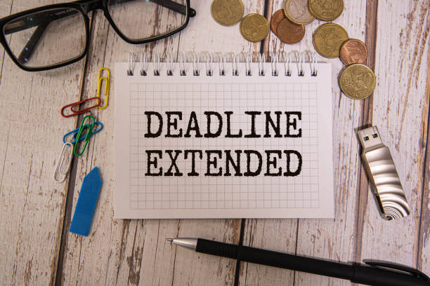 istock Business and finance concept. Phrase DEADLINE EXTENDED written on notebook with a pen,calculator,coins and fake money 2033935378